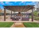 A covered outdoor patio includes a ceiling fan and a brick fireplace with outdoor seating at 7470 Eldora Av, Las Vegas, NV 89117
