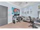 Bedroom with a desk setup, gray sofa, carpeted floor, and walls adorned with decorative artwork at 756 Arden Valley Ave, Henderson, NV 89011