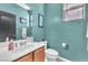Powder room featuring teal walls, framed art, toilet, and vanity with sink at 756 Arden Valley Ave, Henderson, NV 89011
