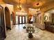 Grand foyer with high ceilings, custom ironwork, and chandelier, with an arched doorway, columns, and elegant tile flooring at 7625 Coley Ave, Las Vegas, NV 89117