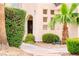 Landscaped entrance with a stone pathway, mature tree, and unique architectural details at 7840 Millhopper Ave, Las Vegas, NV 89128