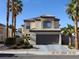 Charming two-story home featuring a two-car garage and meticulously landscaped front yard with mature palm trees at 7840 Millhopper Ave, Las Vegas, NV 89128