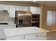 Kitchen features white cabinetry, stainless steel appliances, and a center island with quartz countertop at 7840 Millhopper Ave, Las Vegas, NV 89128