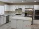 Modern kitchen features white cabinets, stainless steel appliances, and a center island with seating at 7840 Millhopper Ave, Las Vegas, NV 89128