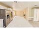 Spacious kitchen with white cabinetry, granite counters, stainless appliances and views into the living area at 7840 Millhopper Ave, Las Vegas, NV 89128