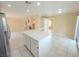 Open kitchen features center island, white cabinetry, tile flooring and easy access to living area at 7840 Millhopper Ave, Las Vegas, NV 89128