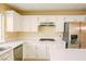 Updated kitchen features white cabinetry, stainless steel appliances, granite countertops, and a gas cooktop at 7840 Millhopper Ave, Las Vegas, NV 89128