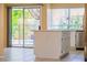 Bright kitchen features a center island, white cabinetry, stainless steel appliances and backyard views at 7840 Millhopper Ave, Las Vegas, NV 89128