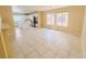 Bright living room featuring tile floors and an open concept kitchen with an island at 7840 Millhopper Ave, Las Vegas, NV 89128