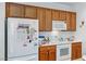 Practical kitchen featuring wooden cabinets and essential white appliances at 7934 Kiskadee St, North Las Vegas, NV 89084
