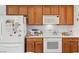 Cozy kitchen featuring wooden cabinets and essential white appliances at 7934 Kiskadee St, North Las Vegas, NV 89084