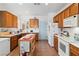 Bright kitchen featuring wooden cabinets, white appliances, and tile flooring at 7934 Kiskadee St, North Las Vegas, NV 89084