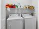 Bright laundry room featuring a washer, dryer, and overhead shelf storage for convenience at 7934 Kiskadee St, North Las Vegas, NV 89084