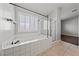 Bright bathroom featuring a soaking tub, glass-enclosed shower, and tile surround at 8029 Chablis Bay St, Las Vegas, NV 89131