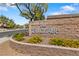 Attractive stone monument sign for The Enclave community features yellow flowers at 8029 Chablis Bay St, Las Vegas, NV 89131