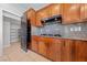 Kitchen featuring granite counters, wood cabinets, black gas cooktop, and door to pantry at 8029 Chablis Bay St, Las Vegas, NV 89131