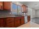 Kitchen area with stainless dishwasher, wood cabinetry, and granite countertops at 8029 Chablis Bay St, Las Vegas, NV 89131