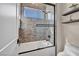 Sleek bathroom with modern bathtub, glass shower, contemporary tile work, and floating shelves for storage at 819 Bolide St, Las Vegas, NV 89138