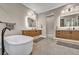 Spa-like bathroom with a soaking tub, dual vanities, and modern lighting fixtures at 819 Bolide St, Las Vegas, NV 89138