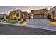 Modern home boasts a paved driveway, manicured lawn, professional landscaping, and attractive exterior lighting at 819 Bolide St, Las Vegas, NV 89138