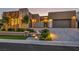 Stunning modern home featuring sleek design, a paved driveway, well-manicured lawn, and enhanced lighting at 819 Bolide St, Las Vegas, NV 89138