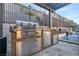 Modern outdoor kitchen with stainless steel grill, countertop, and refrigeration near a swimming pool at 819 Bolide St, Las Vegas, NV 89138
