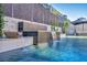 A luxurious swimming pool with a water feature and cascading waterfall in the background at 819 Bolide St, Las Vegas, NV 89138