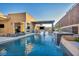 Stunning pool area with waterfall feature, modern patio furniture, and outdoor kitchen under a shaded pergola at 819 Bolide St, Las Vegas, NV 89138