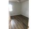 Inviting bedroom featuring modern wood-look floors, white walls, and natural light from a window at 8901 Kingsmill Dr, Las Vegas, NV 89134