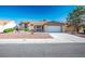 Charming single-story home with a tiled roof, desert landscaping, and an attached two car garage at 8901 Kingsmill Dr, Las Vegas, NV 89134