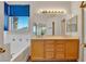Bathroom with double sink vanity, soaking tub and natural light from blinds at 8940 Emery Lake St, Las Vegas, NV 89123
