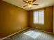 A carpeted bedroom featuring a ceiling fan, window, and warm, inviting neutral color palette at 8940 Emery Lake St, Las Vegas, NV 89123