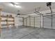 Spacious garage with two car doors and a white ceiling and concrete floor at 8940 Emery Lake St, Las Vegas, NV 89123