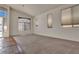 Bright living room featuring plush carpeting, large windows, and a vaulted ceiling at 8940 Emery Lake St, Las Vegas, NV 89123