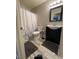 Well-lit bathroom featuring a vanity with dark cabinets, a toilet and shower with a decorative curtain at , Las Vegas, NV 89106