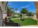 Beautifully landscaped front yard with artificial grass, stone accents, and a variety of trees and plants at , Las Vegas, NV 89146