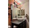 Bathroom featuring unique decorative mirror and sink, complemented by a brick-patterned wall and industrial shelving at 10403 Fancy Fern St, Las Vegas, NV 89183