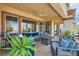 Inviting outdoor patio with a cozy seating area, ceiling fan, and lush landscaping at 10408 Mezzanino Ct, Las Vegas, NV 89135