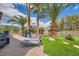 Relaxing backyard with artificial turf, palm trees, lounge chairs, barbecue, and comfortable outdoor seating at 10408 Mezzanino Ct, Las Vegas, NV 89135