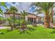 Lush backyard featuring artificial turf, desert landscaping, a covered patio, and a neutral colored home exterior at 10408 Mezzanino Ct, Las Vegas, NV 89135