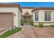 Front entrance with iron gate, potted plants, and tan stucco exterior at 10408 Mezzanino Ct, Las Vegas, NV 89135