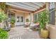 Outdoor patio with comfortable seating, brick flooring, pergola, and lush plants at 10408 Mezzanino Ct, Las Vegas, NV 89135