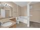 Bathroom with dual sinks, granite counters, soaking tub and separate walk-in closet at 10550 W Alexander Rd # 2233, Las Vegas, NV 89129