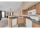 Functional kitchen featuring white appliances, wood cabinets, and neutral countertops at 10550 W Alexander Rd # 2233, Las Vegas, NV 89129