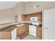 Functional kitchen featuring white appliances, wood cabinets, and neutral countertops at 10550 W Alexander Rd # 2233, Las Vegas, NV 89129