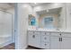 Bright bathroom featuring double vanity with white cabinets and framed mirrors, plus a glass-enclosed shower at 10777 Briset Ct, Las Vegas, NV 89166