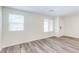 A spacious bedroom with wood-look floors, white walls, and a large window for natural light at 10777 Briset Ct, Las Vegas, NV 89166
