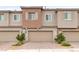 Attached garages with brick driveways, complemented by small trees and neutral-toned townhome exteriors at 10777 Briset Ct, Las Vegas, NV 89166
