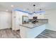 This kitchen features a breakfast bar, recessed lighting, stainless steel appliances and wood grain flooring at 10777 Briset Ct, Las Vegas, NV 89166