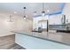 This kitchen features a breakfast bar, recessed lighting and stainless steel appliances, and wood grain flooring at 10777 Briset Ct, Las Vegas, NV 89166